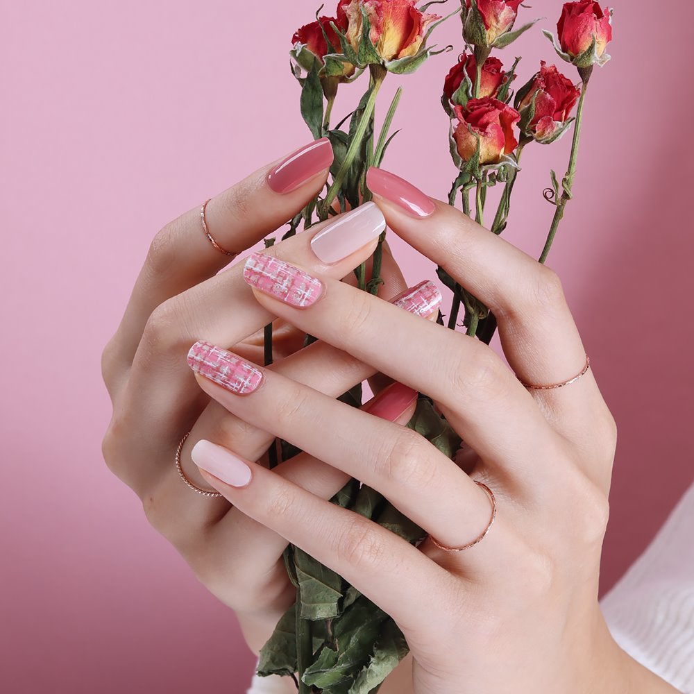 Glossy Blossom Rose Tweed gel nail strips on nails, showcasing elegant pink and beige floral design for trendy manicures.