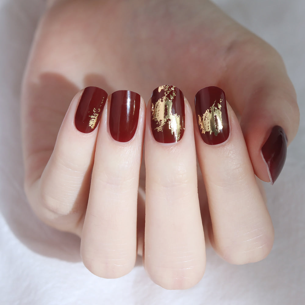 Glossy Blossom Burgundy Foil Art gel nail strips on nails with metallic foil design for a stylish manicure.
