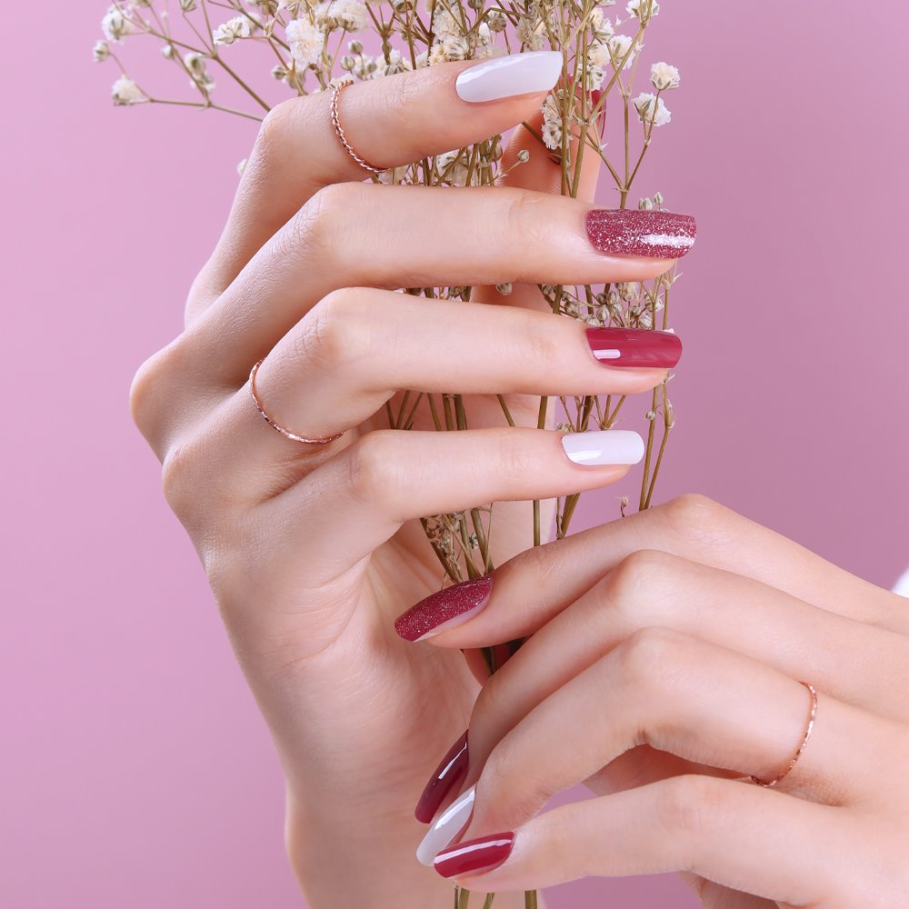 Glossy Blossom Carmine Rose gel nail strips on neatly manicured nails showcasing vibrant pink and red floral design.