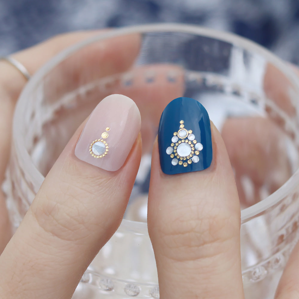 Glossy Blossom blue eye gel nail strips applied on nails with detailed blue eye pattern for a stylish manicure.