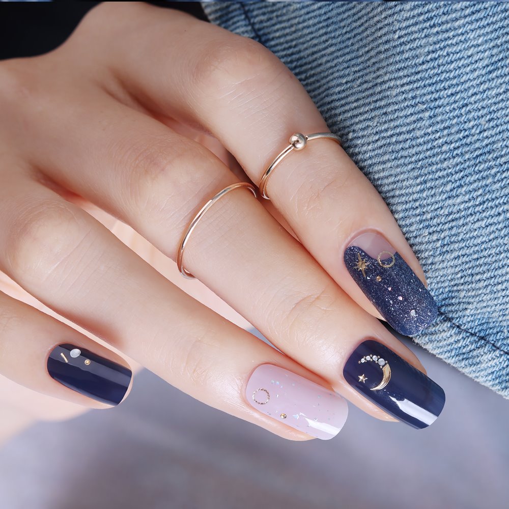 Glossy Blossom Midnight Sky gel nail strips applied on nails with a dark, starry sky design.