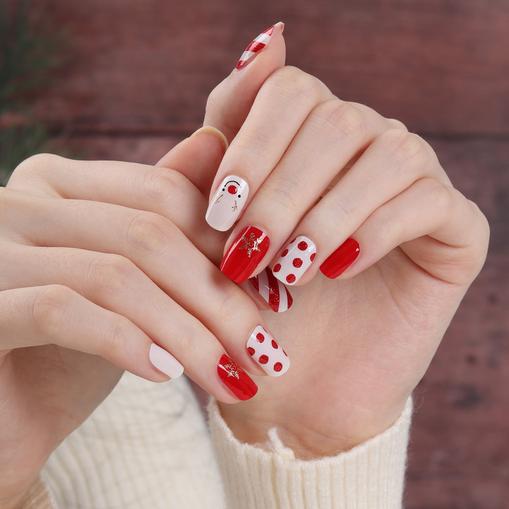Glossy Blossom Merry Holiday gel nail strips applied on nails with festive red and green holiday-themed designs.