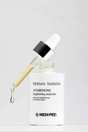 Derma Maison Vitabenone Brightening Ampoule 100ml in a clear glass bottle showing a dropper applicator and luminous liquid inside.