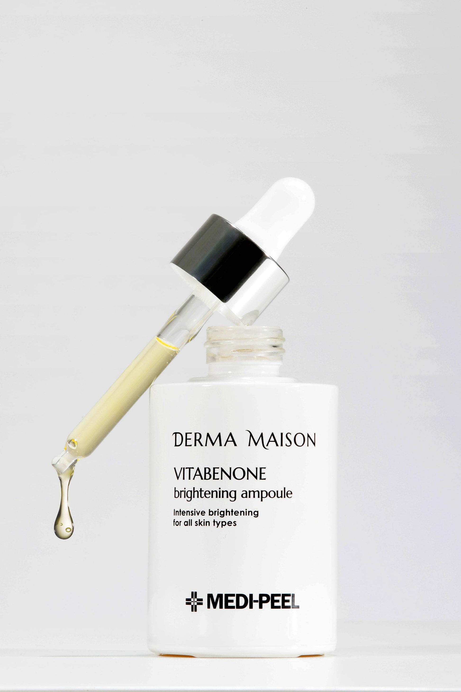 Derma Maison Vitabenone Brightening Ampoule 100ml in a clear glass bottle showing a dropper applicator and luminous liquid inside.