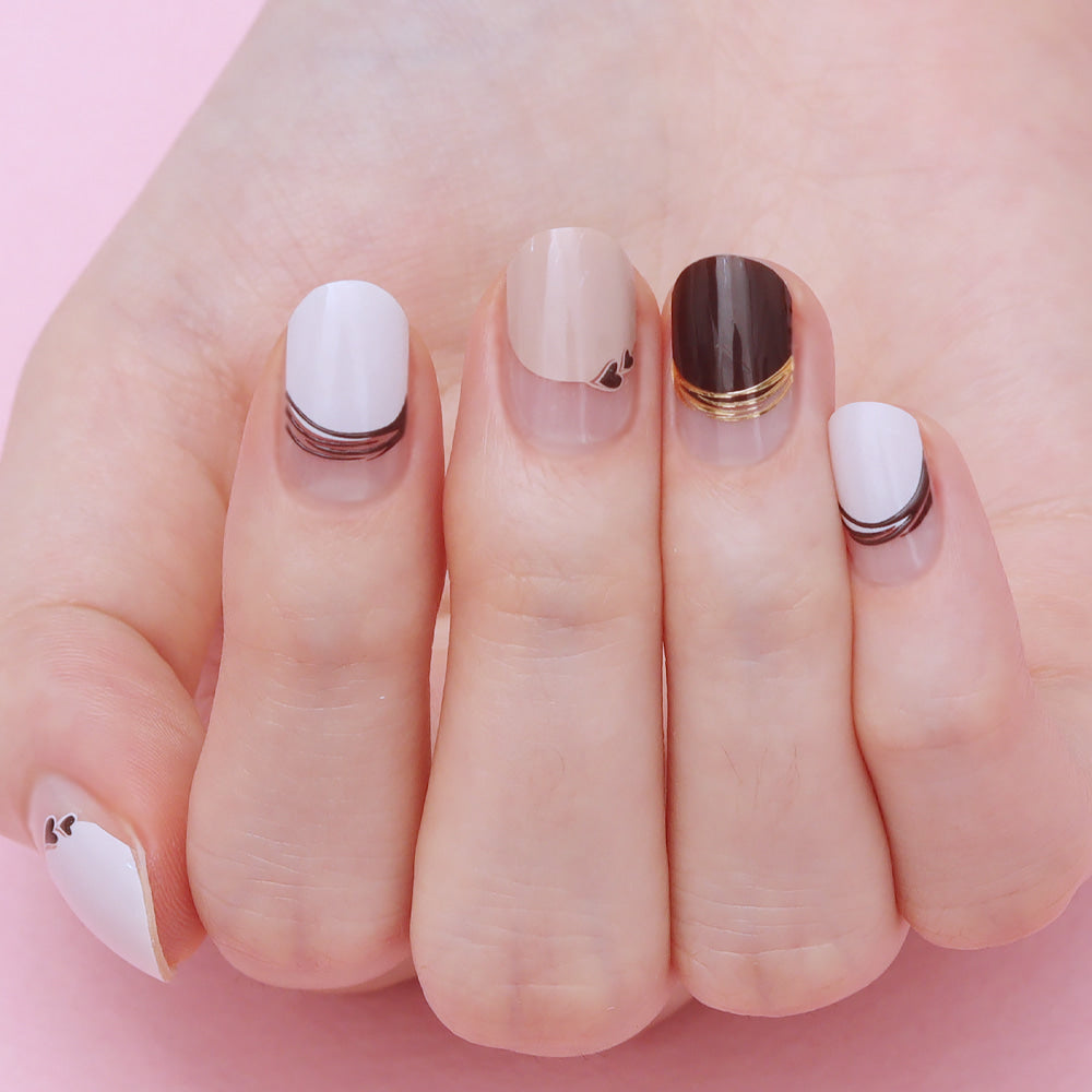 Glossy Blossom gel nail strips in Sweet Filled Latte with latte and pastel designs on neatly manicured nails.